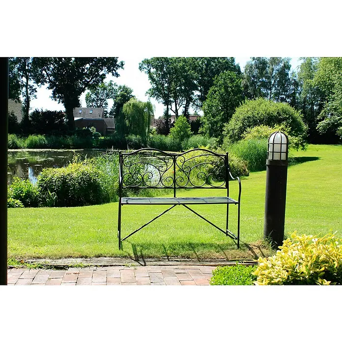 Garden Pleasure Gartenbank Vesuv - B x T x H: 111 x 54 x 93 cm, Stahl, Schwarz-Matt - Schwarze Gartenbank aus Metall mit verzierter Rückenlehne in einem üppigen Garten.