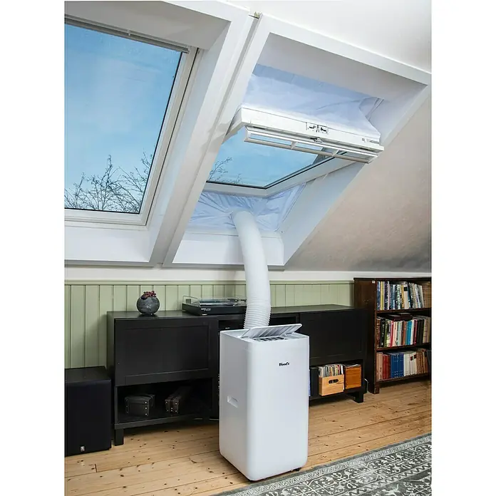 Woods Fensterabdichtung Dachfenster für mobile Klimageräte von Woods - Weiß, Breite: 39 cm - Weißes mobiles Klimagerät mit Abluftschlauch, der über einen weißen Stoff-Fensterbausatz an ein geöffnetes Dachfenster angeschlossen ist.