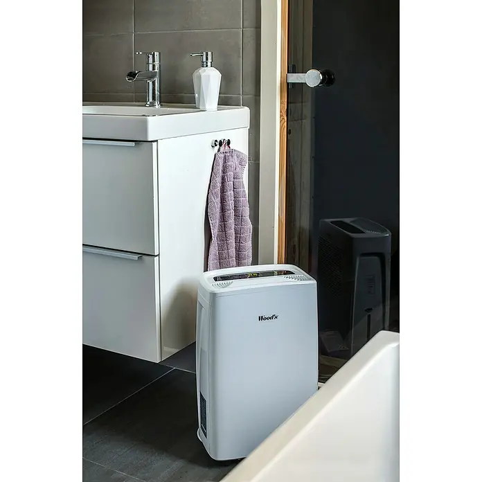 Woods Elektro-Luftentfeuchter MDX 14 - 220 W, Entfeuchtungsleistung: 10 l/Tag, Weiß - Weißer Wood's Luftentfeuchter in einem modernen Badezimmer, neben einem Waschbeckenunterschrank.
