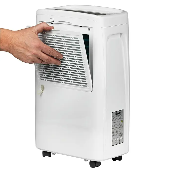 Woods Elektro-Luftentfeuchter MDX 14 - 220 W, Entfeuchtungsleistung: 10 l/Tag, Weiß - Weißer Luftentfeuchter, bei dem eine Hand die seitliche Filterabdeckung öffnet, um das Filterfach zu zeigen.