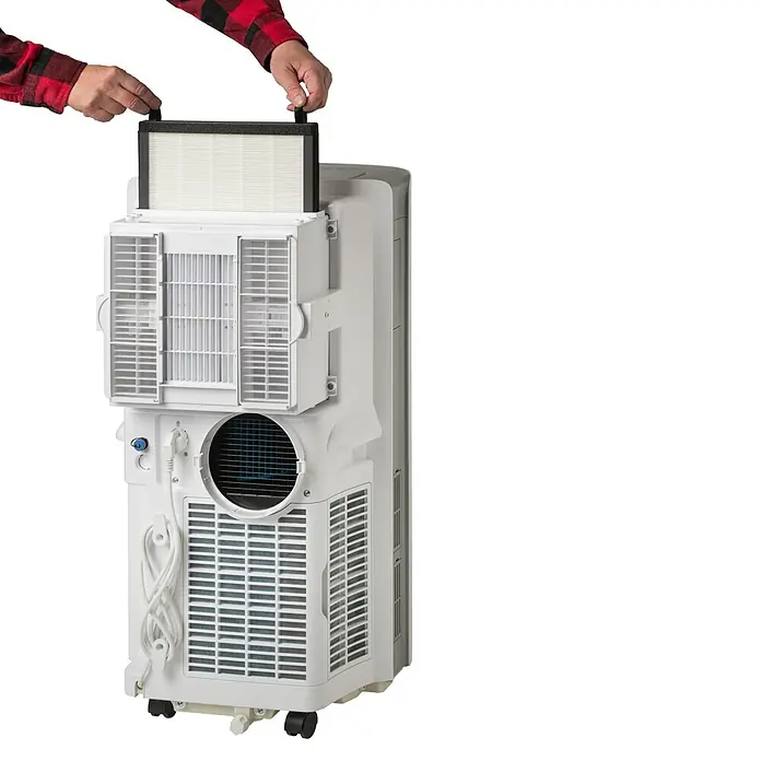 Woods Mobiles Klimagerät Cortina 12K AirSwitch DUO A+ - 3,5 kW, Raumgröße: 35 m², Weiß - Hände setzen einen neuen weißen Filter in ein weißes tragbares Klimagerät zur Wartung ein.