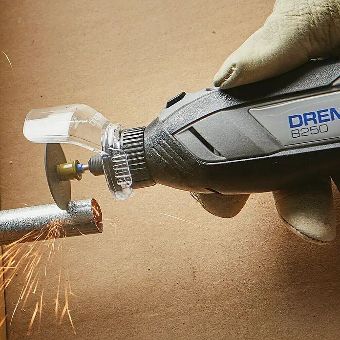 Akku-Multifunktionswerkzeug - 12 V, 1 Akku, 2 Ah, 65-tlg. Zubehör + 5 Vorsätze + Tragekoffer - Detailaufnahme eines Dremel 8250 Multifunktionswerkzeugs beim Schneiden eines Metallrohrs, wodurch Funken entstehen.