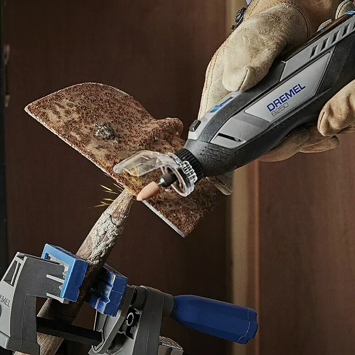 Akku-Multifunktionswerkzeug - 12 V, 1 Akku, 2 Ah, 65-tlg. Zubehör + 5 Vorsätze + Tragekoffer - Der Dremel 8250 beim Bearbeiten eines Metallstücks mit Funkenflug. Ein praktisches Werkzeug für Präzisionsarbeiten und zum Schleifen von Metall.