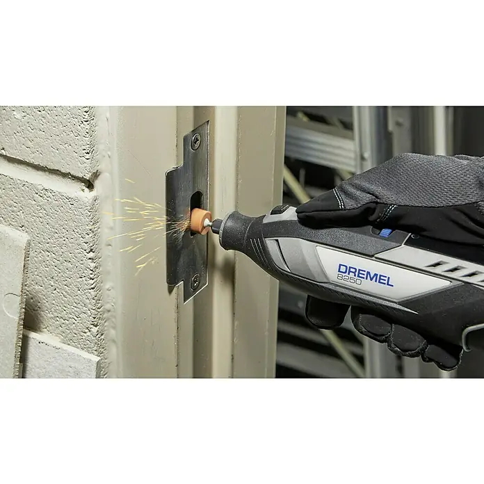Akku-Multifunktionswerkzeug - 12 V, 1 Akku, 2 Ah, 65-tlg. Zubehör + 5 Vorsätze + Tragekoffer - Dremel 8250 Multifunktionswerkzeug beim Bearbeiten eines Türschlosses, Funken fliegen. Ideal zum Schleifen und Polieren von Metalloberflächen.