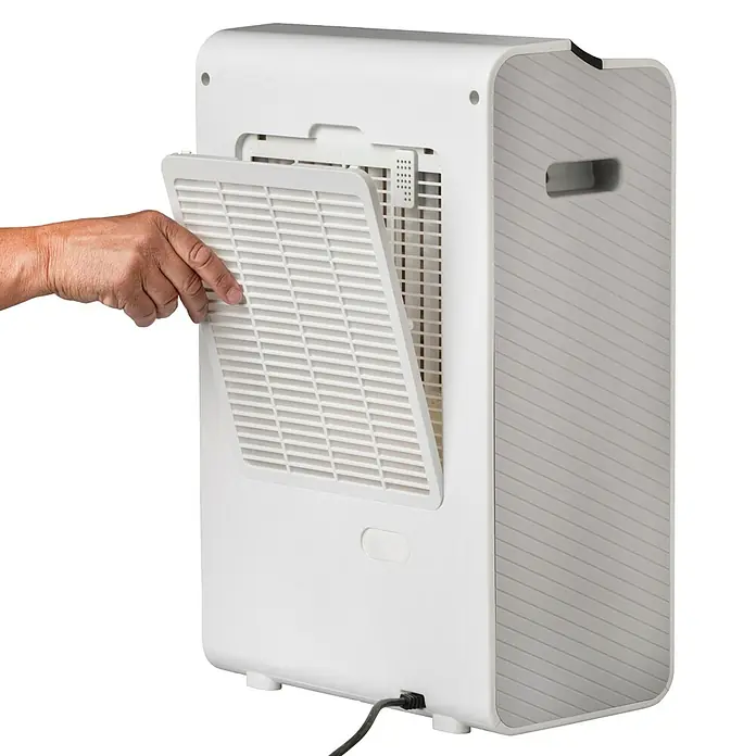 Woods Elektro-Luftentfeuchter WDD 90 Wifi - 610 W, Entfeuchtungsleistung: 8 l/Tag, L x B x H: 35,8 x 21,3 x 53,7 cm, Weiß - Weiß-graues mobiles Klimagerät, eine Hand öffnet die hintere Filterabdeckung.