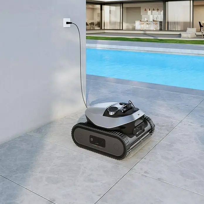 Dreame Poolroboter Z1 Pro - Akkubetrieben, Passend für: Pools bis 200 m² Grundfläche, Filterleistung: 30.000 l/h - Silber-schwarzer Poolroboter lädt neben einem modernen Schwimmbad, bereit zur effizienten Reinigung.
