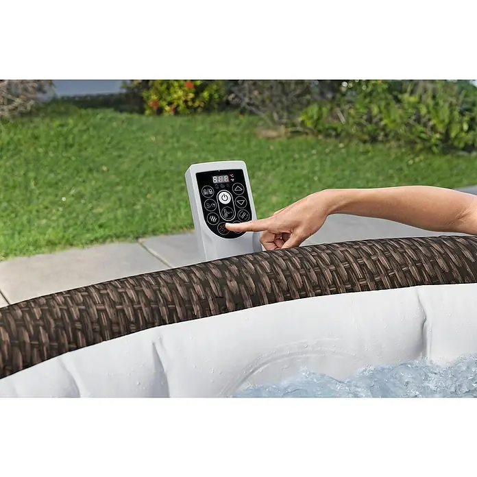 Bestway Lay-Z-Spa Mobil-Whirlpool Bali - Ø x H: 216 x 71 cm, Braun, 1.260 l - Eine Hand bedient das Bedienfeld eines Whirlpools, um die Temperatur einzustellen oder Funktionen zu aktivieren.\n