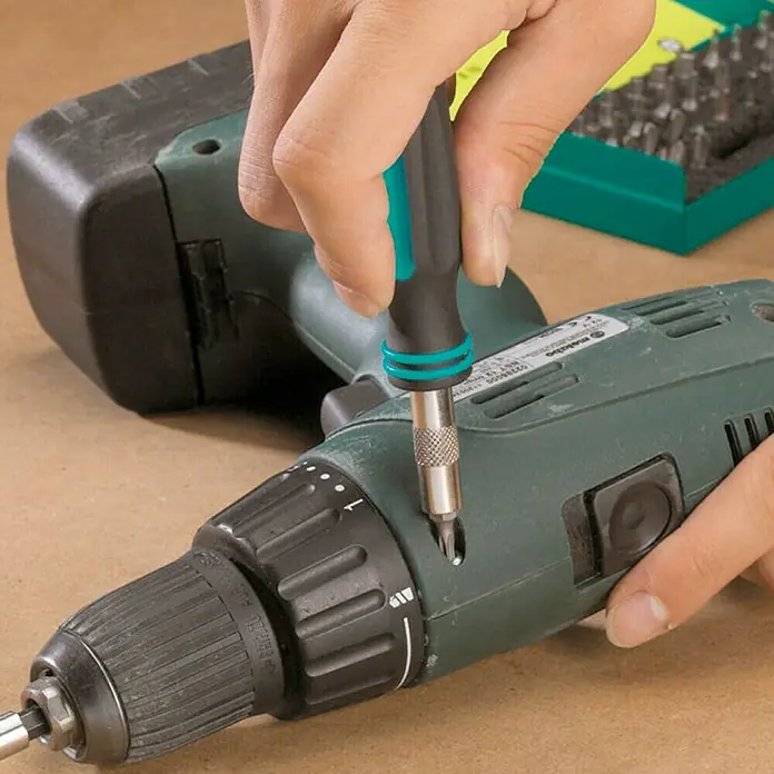 Wolfcraft Set de puntas - 31 pzs. - Un taladro inalámbrico está siendo reparado con un destornillador, insertado en un tornillo de la carcasa. Trabajo de precisión.