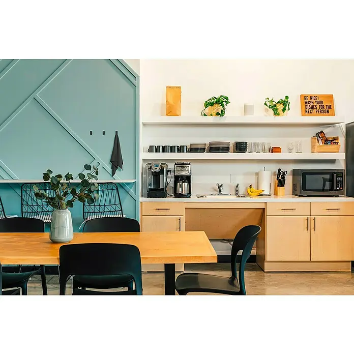 Tesa Powerstrips Selbstklebehaken - Eckig, Größe: S, Schwarz, 3 Stk. - Helle Bürokantine mit Holztisch, schwarzen Stühlen, Regalen und Geräten wie Kaffeemaschine und Mikrowelle.