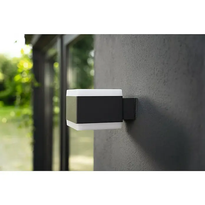 Tesa Ultra Power Klettpad Lock Tape - L x B: 1 m x 25 mm, Schwarz - Nahaufnahme einer modernen, quadratischen Wandleuchte mit schwarzem Gehäuse und weißen Diffusoren, die an einer grauen Wand montiert ist.