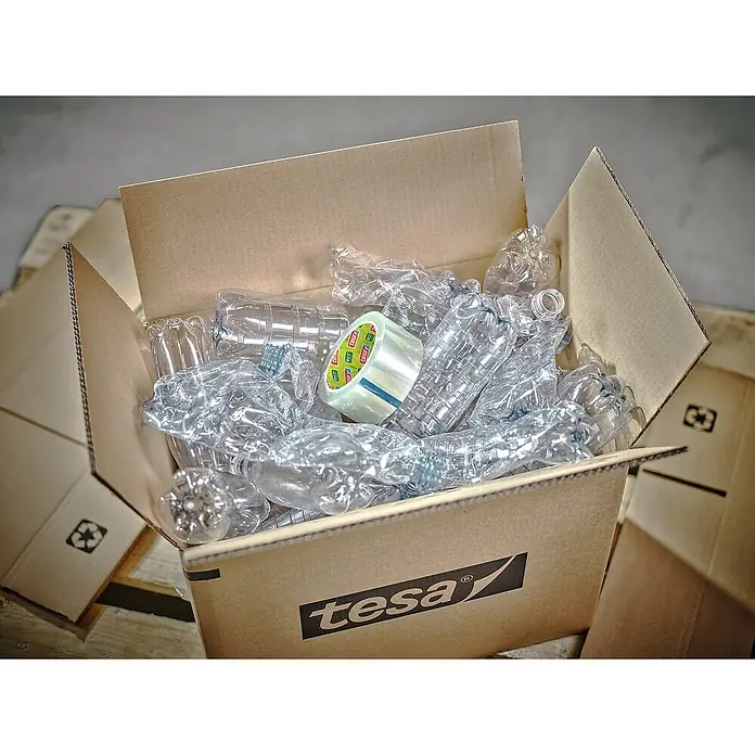 Tesa Pack Paketklebeband Eco & Ultra Strong - Transparent, L x B: 66 m x 50 mm - Eine Tesa-Kartonbox gefüllt mit leeren Plastikflaschen und einer Rolle Tesa-Band, bereit zum Recyceln. Umweltbewusstes Handeln im Alltag.