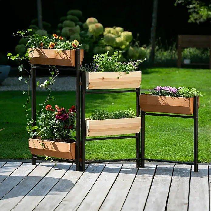 Dobar Hochbeet Flexi - L x B x H: 165 x 18 x 105 cm, Holz, Schwarz, Braun, Natur - Das Bild zeigt einen hölzernen, mehrstöckigen Pflanzenständer mit verschiedenen Blumen und Pflanzen auf einer Holzterrasse.