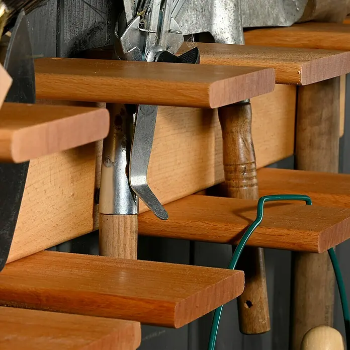 Dobar Gerätehalter groß - L x B x H: 96 x 15 x 14 cm, Rotbuche - Nahaufnahme eines Werkzeugregals mit verschiedenen Gartengeräten wie Harken, Spaten und Scheren. Die Werkzeuge sind sauber und einsatzbereit.