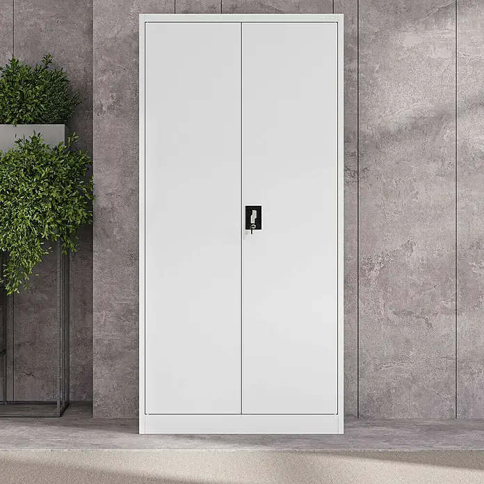 Jan Nowak Aktenschrank Jan - B x T x H: 90 x 40 x 185 cm, Weiß - Weißer zweitüriger Metallschrank mit Schloss, vor einer Betonwand neben einer grünen Pflanze.