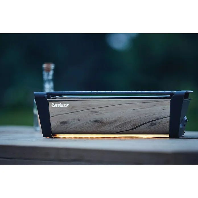 Enders Elektrogrill Aurora - MIrror-Schwarz, Grillfläche (B x T): 37 x 25 cm - Ein Enders Elektrogrill mit heller Holzfront und orangefarbenem Leuchten darunter auf einem Holztisch.