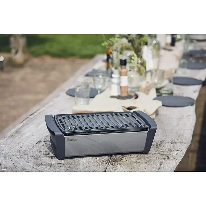 Enders Elektrogrill Aurora - Grau, Grillfläche (B x T): 37 x 25 cm - Kompakter, dunkelgrauer Enders Tischgrill auf einem Holztisch im Freien, bereit zum Essen.