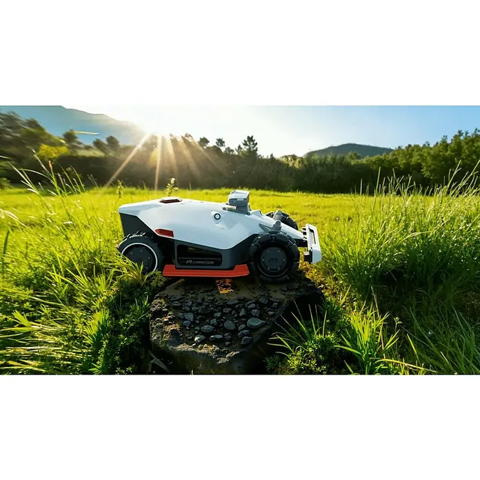 Mammotion Mähroboter Luba 2 AWD 3000X - 3.000 m², Schnittbreite: 400 mm, Satellitengestützte Navigation, GPS - Weißer und grauer Mähroboter mit schwarzen Rädern und orangefarbenem Unterboden ruht auf einem Stein in einem sonnigen Grasfeld.