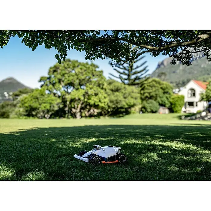 Mammotion Mähroboter Luba 2 AWD 3000X - 3.000 m², Schnittbreite: 400 mm, Satellitengestützte Navigation, GPS - Weißer und schwarzer Rasenroboter mit orangefarbenen Akzenten, auf Rasen unter einem Baum.