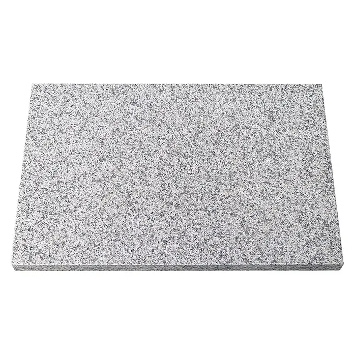 Terrassenplatte G 603 - 60 x 40 x 3 cm, Grau, Granit - Nahaufnahme einer polierten Granitplatte in Grau- und Weißtönen mit einer feinen, gleichmäßigen Körnung. Ideal für Arbeitsplatten und Bodenbeläge.