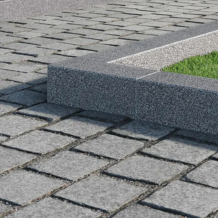 Palisade G 654 - 25 x 10 x 12 cm, Anthrazit - Nahaufnahme eines Pflasterwegs mit einer Steinbegrenzung und grünem Gras. Das Pflaster und die Steine haben eine graue Farbe mit einer unebenen Textur.