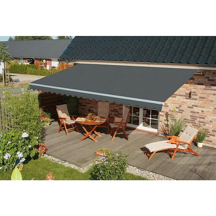 Spettmann Gelenkarmmarkise Star Fix 2327 - Grau, Farbe Gestell: Weißaluminium, Breite: 4 m, Ausfall: 3 m - Eine dunkelgraue Stoffmarkise über einer Terrasse mit Gartenmöbeln, die Schatten spendet.