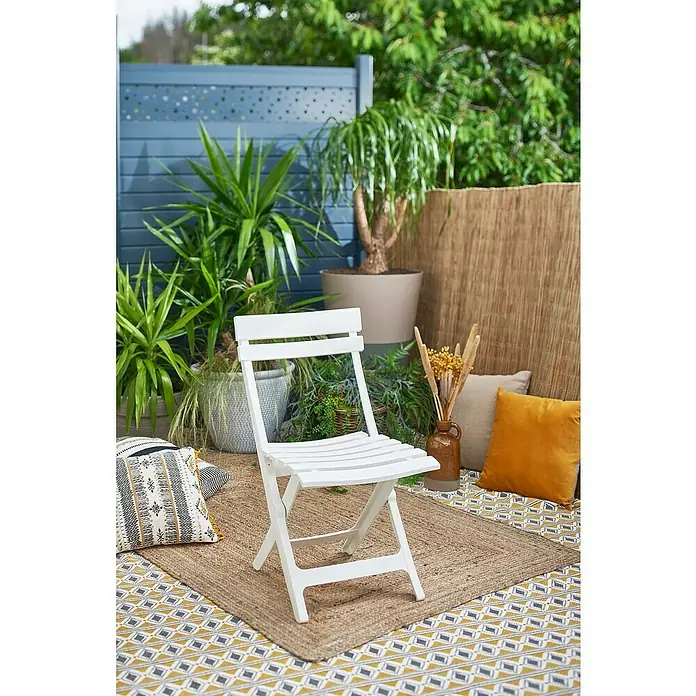 Grosfillex Klappstuhl Set Miami - 2 Stk., Polypropylen, Klappbar, Weiß, B x T x H: 42 x 50 x 93 cm - Weißer Klappstuhl offen auf einem Teppich in einem Outdoor-Terrassenambiente mit Pflanzen und Kissen.