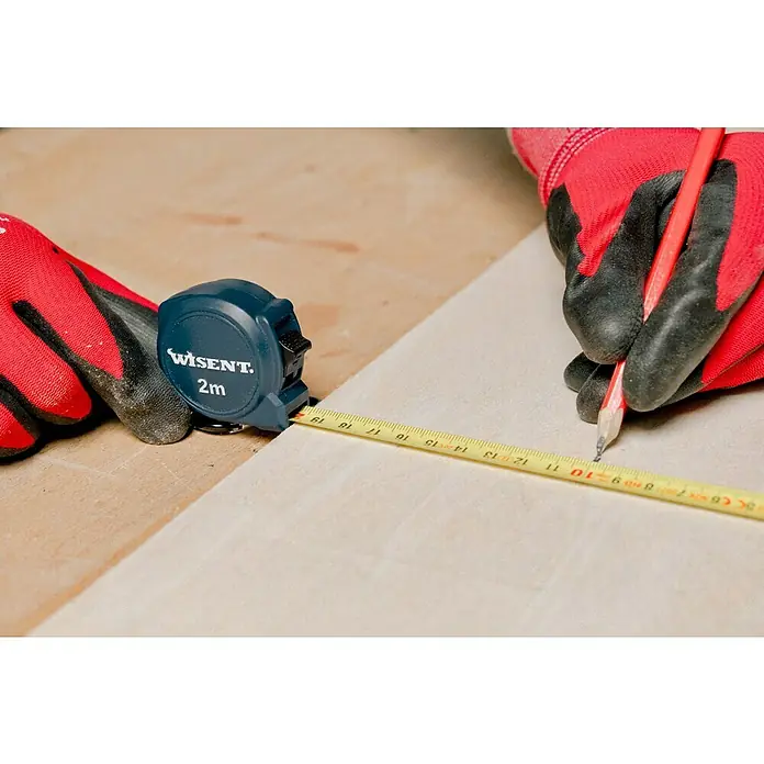 Wisent Kapselmaßband - 2 m, Ausstattung: Spikes-Haken - Hände in rot-schwarzen Handschuhen verwenden ein blaues WISENT 2m Maßband und einen roten Bleistift, um eine helle Oberfläche zu markieren.