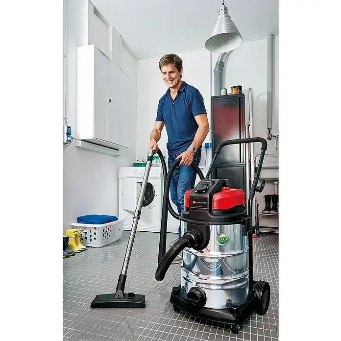 Einhell Saugschlauch - Länge: 3 m, Durchmesser: 36 mm - Ein Mann benutzt einen Einhell Nass-Trockensauger im Haus, um den Boden zu reinigen. Der Staubsauger ist silberfarben mit einem roten Deckel.