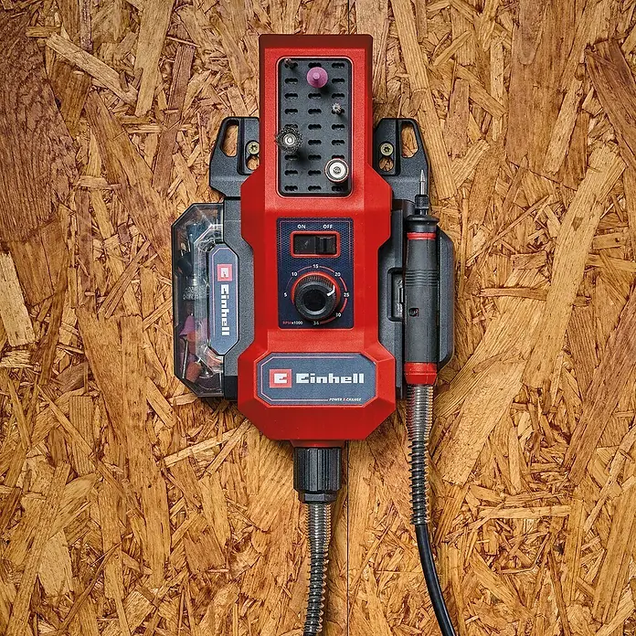 Einhell Power X-Change 18V Schleif- & Gravurwerkzeug TE-MT 18/34 Li-Solo - Ohne Akku, 5.000 U/min - 34.000 U/min - Nahaufnahme eines roten Einhell Akku-Bohrschleifers an einer Holzwand, der ordentlich und griffbereit montiert ist.