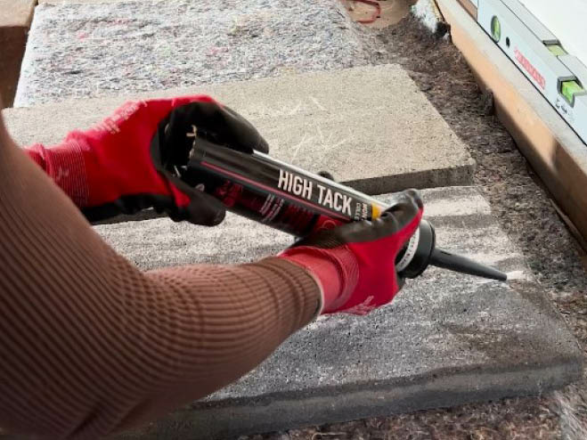 Montagekleber wird auf eine graue Steinplatte augetragen