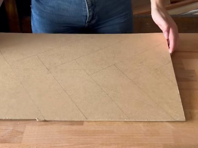 Ausgeschnittene MDF-Platte am Tisch, mit Bleistift wurden Linien für später zum Bekleben eingezeichnet