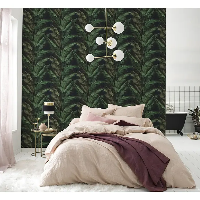 Tesa Rasch Strukturtapete Rio Blatt - Selbstklebend, Grün/Schwarz, Floral, 6 x 0,53 m - Elegantes Schlafzimmer mit beigefarbener Bettwäsche, dunkelgrüner Blättertapete und moderner Pendelleuchte.