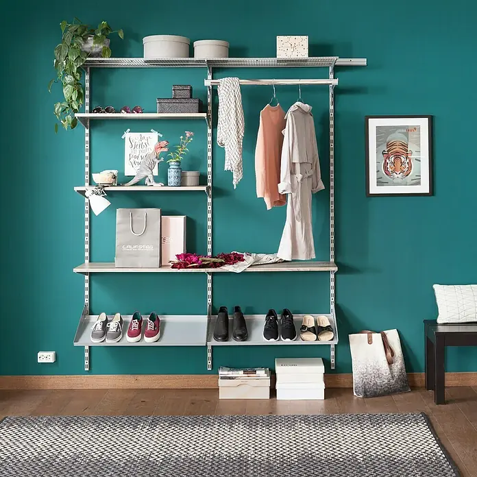 Element System Twin Drahtbodenträger - Länge: 32 cm, Belastbarkeit: 30 kg, Weiß/Aluminium - Das Bild zeigt ein begehbares Schranksystem mit Regalen, einer Kleiderstange und verschiedenen Kleidungsstücken und Accessoires.