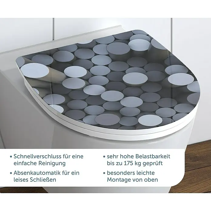 Schütte WC-Sitz Round Dips - Duroplast, Grau/Schwarz, Mit Absenkautomatik - Nahaufnahme eines WC-Sitzes mit grauem Kreisdesign, der sich durch Schnellverschluss und einfache Montage auszeichnet.