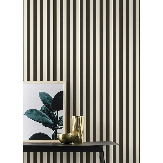 Tesa Rasch Strukturtapete Lenny - Selbstklebend, Schwarz/Beige, Streifen, 6 x 0,53 m - Elegante Inneneinrichtung mit gestreifter Tapete, gerahmtem Pflanzenbild, goldener Schale und Vase auf einem modernen Tisch.