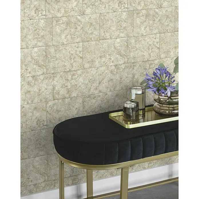 Tesa Rasch Strukturtapete Luxora - Selbstklebend, Beige/Hellgrau, Fliesenoptik, 6 x 0,53 m - Nahaufnahme eines stilvollen, schwarzen Samt-Hockers mit goldenem Gestell, dekoriert mit eleganten Accessoires und Blumen.