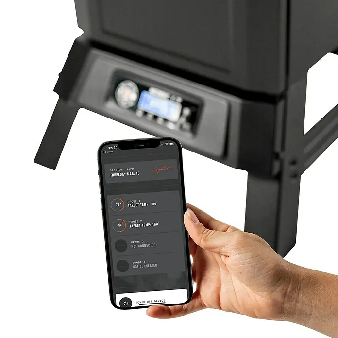Masterbuilt Smoker 710 - Grillfläche (B x T): 53 x 44 cm - Hand hält Smartphone mit Grillsteuerungs-App, die Temperaturmesswerte zeigt, vor einem verschwommenen Grill.