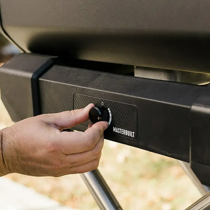 Masterbuilt Holzkohlegrill Portable - Grillfläche (B x T): 41 x 33 cm, Schwarz - Eine Hand verstellt den schwarzen Bedienknopf auf dem Kohlefaser-Panel eines MASTERBUILT Grills.