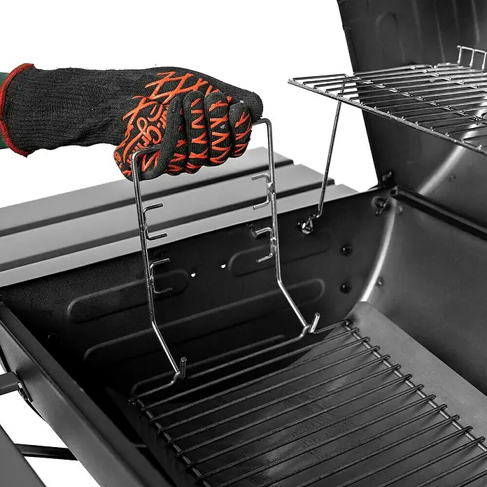 Char-Griller Holzkohlegrill inkl. Offset-Smoker - Grillfläche (B x T): 79 x 44 cm, Schwarz - Hand im Grillhandschuh hebt mit einem Metallrostheber ein schwarzes Grillrost im Grill an.