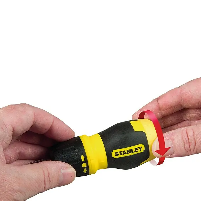 Stanley Vergaser Schraubendreher Stubby - 7 -tlg. - Nahaufnahme eines Stanley-Schraubendrehers in der Hand, mit einem roten Pfeil, der die Drehbewegung veranschaulicht.