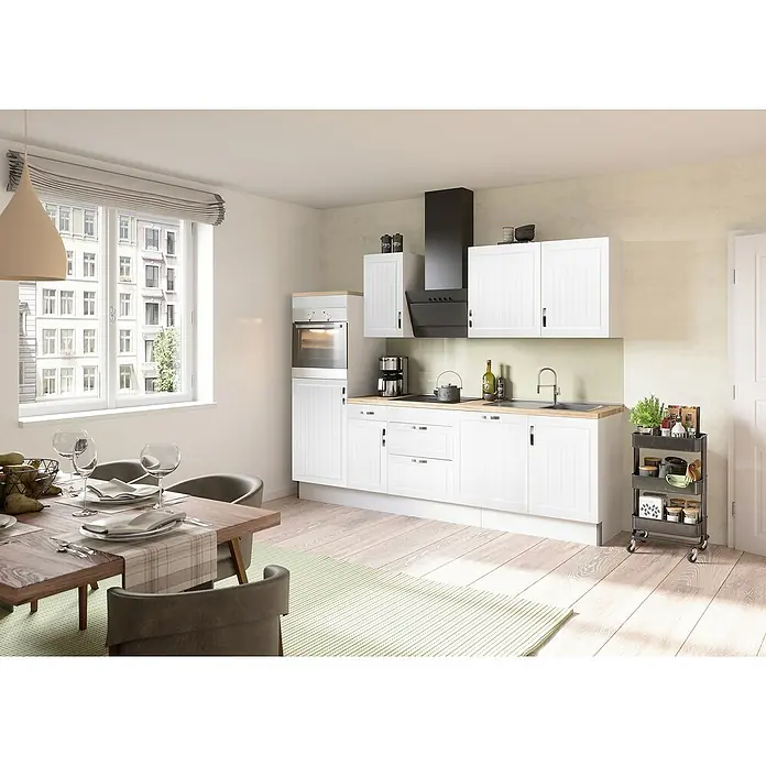 Optifit Küchenzeile Juna 969 - Typ 2 - Breite: 270 cm, Landhaus Weiß, Mit Elektrogeräten - Helle Küche mit weißen Schränken, Esstisch mit Geschirr und Küchenwagen. Eine moderne Küchenzeile mit viel Stauraum und funktionalem Design.