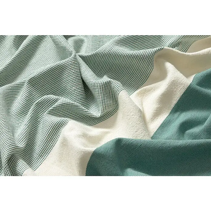 Manta para sofá Vigore Rayas - Textil, Verde - Primer plano de un paño de algodón con tejido de gofre verde y blanco con pliegues, que muestra una textura suave y cómoda.