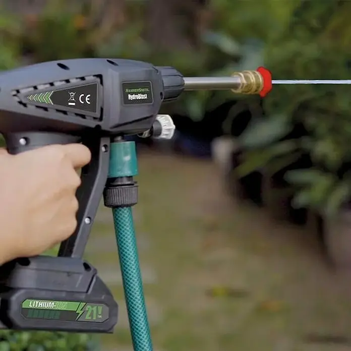 Hidrolimpiadora de alta presión de batería Hydroblast - 9,5 bar, 21 V, Capacidad de bombeo: 210 l/h - Hidrolimpiadora inalámbrica HammerSmith Hydroblast en acción, rociando un chorro de agua, ideal para tareas de limpieza exterior.