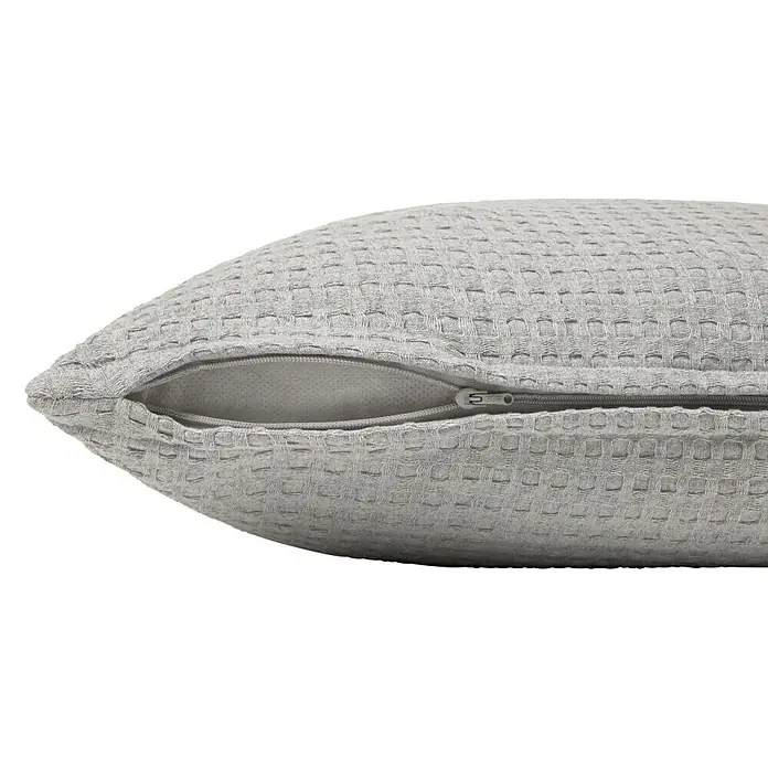 Cojín Waffle - 50 x 50 cm, Textil, Gris, Cuadrado - Primer plano de un cojín decorativo gris con estructura de gofre y una cremallera parcialmente abierta.