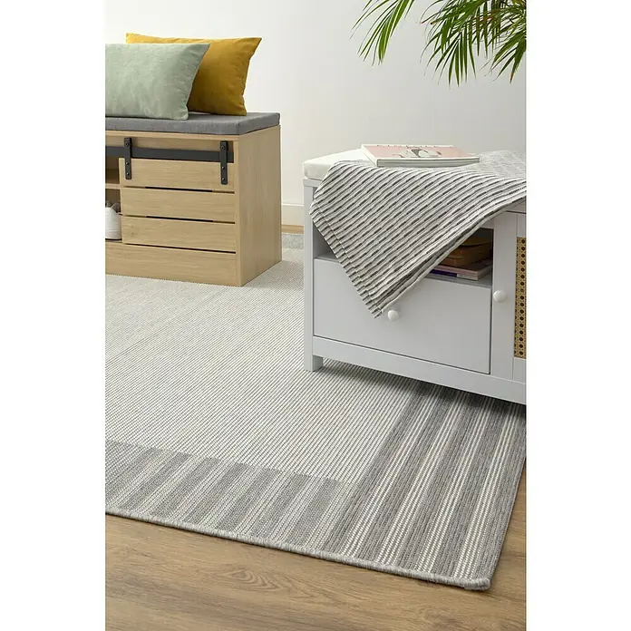 Alfombra exterior In/Out Marco - Gris, 110 x 60 cm, Polipropileno - Primer plano de un revestimiento de suelo de rayas grises y blancas, creando un ambiente acogedor y elegante en la habitación.