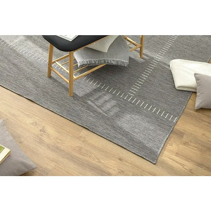 Alfombra exterior reversible In/Out Pespunte - Silver, 230 x 160 cm, Polipropileno - Una alfombra gris con un diseño moderno está sobre un suelo de madera, creando un ambiente elegante en la habitación.