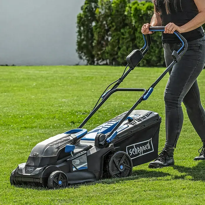 Scheppach IXES 20V Cortacésped de batería BC-MP380-X - 40 V, 2 baterías, 4 Ah, Ancho de corte: 38 cm - Una persona empuja un cortacésped Scheppach inalámbrico negro y azul.
