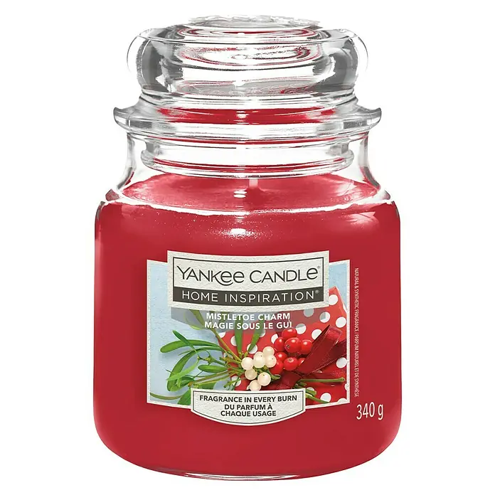 Yankee Candle Home Inspirations Duftkerze - Im Glas, Mistletoe Charm, Medium - Rote Yankee Candle im klaren Glasgefäß mit Deckel, beschriftet mit 'Mistletoe Charm' und Beeren, 340g.