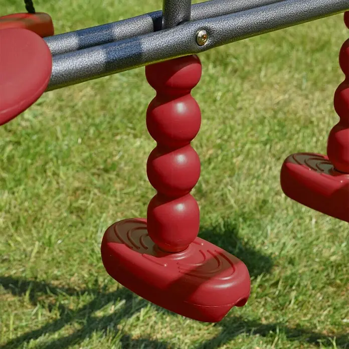 Kinderspielturm Aleks II - L x B x H: 180 x 216 x 195 cm, Rot - Detailaufnahme einer roten Schaukel mit dekorativem Design, die an einem metallenen Spielgerüst befestigt ist, ideal für den Garten.