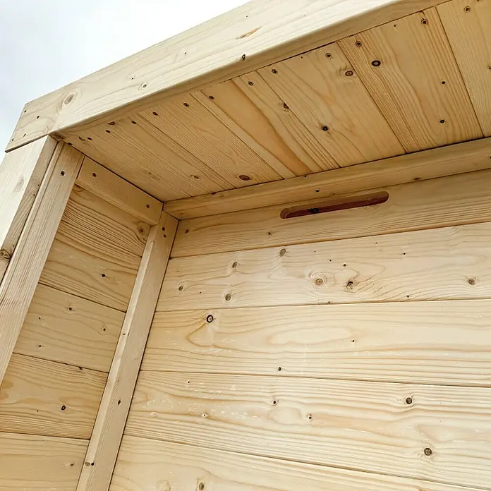 Gerätehaus - Außenbreite inkl. Dachüberstand: 203 cm, Außentiefe inkl. Dachüberstand: 270 cm, Holz, Natur - Innenansicht einer hellen Kiefernholzstruktur mit sichtbaren Planken, Schrauben und einem geschnitzten Griff.